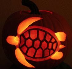 a carved pumpkin with an image of a turtle on it's face in the dark