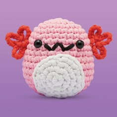 a crocheted pink and white stuffed animal with horns on it's head