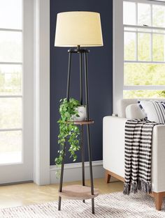 a living room with blue walls and a lamp on the floor next to a couch