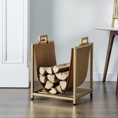 a stack of firewood sitting on top of a wooden floor next to a table