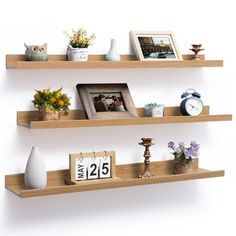 three wooden shelves with pictures, photos and vases on them are arranged next to each other