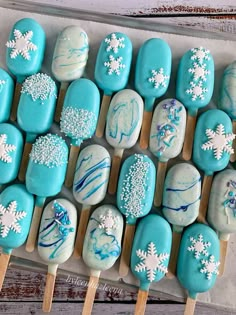 there are many blue and white treats on the stick with snowflakes all over them