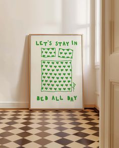 a green and white poster sitting on top of a checkered floor next to a window