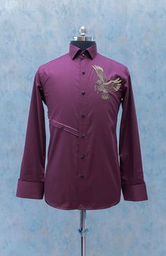 This maroon hand embroidered shirt is a new generation designer shirt with eagle embroidery on the left side and stripes on the right side of the shirt. It's been made in the pure cotton fabric. It suits best for cocktail parties and could also be worn in other parties also and it gives you a high end designer look. Components : 1 Fabric : Giza Cotton Neckline : Straight Collar Cuff : French Cuff (Barrel cuff could also be made on request) Color : Maroon Embroidery : Hand Embroidery - Zardosi wo Formal Embroidered Cotton Shirt, Fitted Cotton Shirt With Embroidered Cuffs, Fancy Kurta For Men, Embroidery Shirt Men, Maroon Embroidery, Formal Dress For Men, Hand Embroidered Shirt, Eagle Embroidery, Gents Kurta Design