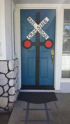 a blue door with railroad crossing sign painted on it