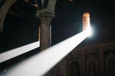 the light shines brightly on an old building's pillars and arches, which are decorated with intricate carvings