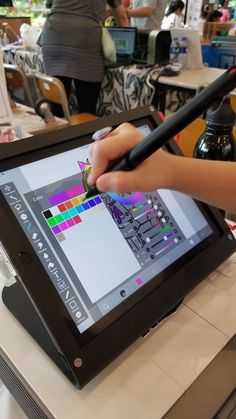 a person holding a pen and drawing on a tablet