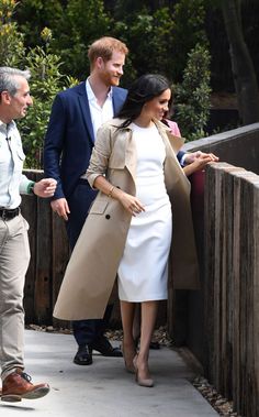 prince harry and his wife, the duke of cambridge, are seen walking along a fence