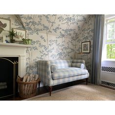 a blue and white couch sitting in front of a fireplace