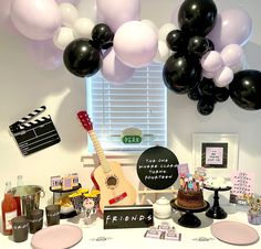 a table topped with black, white and pink balloons