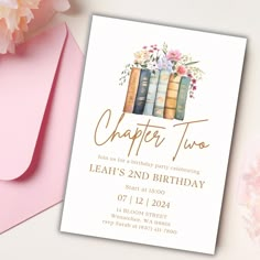 a birthday party card with books and flowers on the front, next to pink envelopes