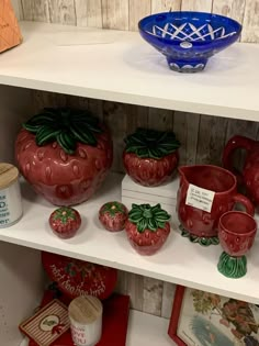 the shelves are filled with ceramic strawberrys and other decorative items, including mugs