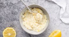 a bowl filled with mashed potatoes next to sliced lemons