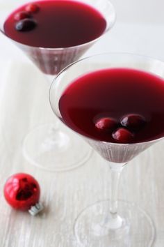 two glasses filled with red liquid and cherries