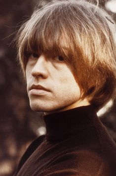 a close up of a person wearing a turtle neck sweater and looking off to the side