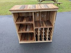 a wooden cabinet with many compartments on the top and bottom, in front of a picnic table