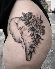 an elephant with flowers on it's back is seen in this tattoo design by the artist