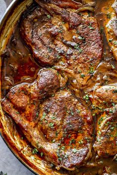 some meat in a pot with sauce and parsley on the side for garnish