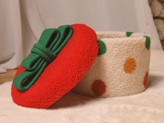 two red and green hats sitting on top of a white bed next to each other