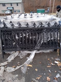 a man standing next to a metal fence covered in plastic