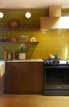 a stove top oven sitting inside of a kitchen next to a counter with dishes on it