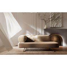 a couch sitting on top of a hard wood floor next to a white vase with flowers