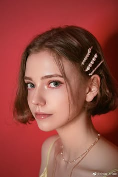 a woman wearing a hair comb with pearls on it's head, against a red background