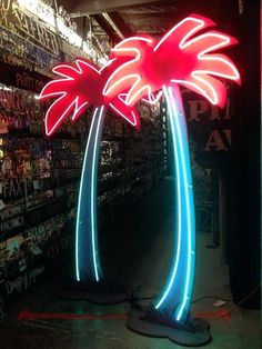 two palm trees are lit up with neon lights