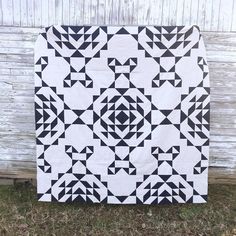 a black and white quilt sitting on top of grass