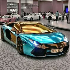 a blue and gold colored sports car in a showroom