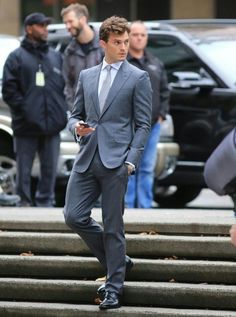 a man in a suit walking down some steps