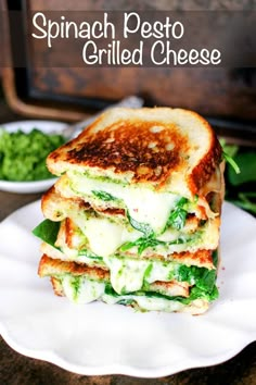 spinach pesto grilled cheese sandwich on a white plate with basil leaves in the background