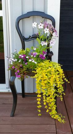 a chair with flowers in it sitting on a deck