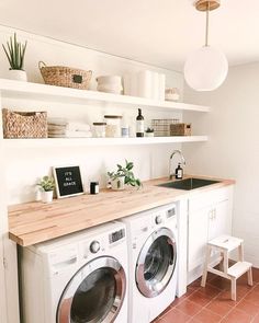 a washer and dryer sitting in a room next to a counter with plants on it