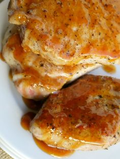 two pieces of chicken covered in gravy on a white plate