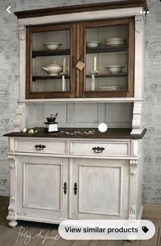 an old fashioned china cabinet with glass doors and wood trimmings on the top