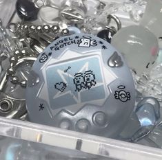 a container filled with lots of different types of buttons and other metal objects in it