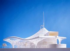 an architectural model of a white building against a blue sky