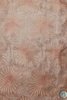 an old pink and gold brocaded cloth with flowers on it's side