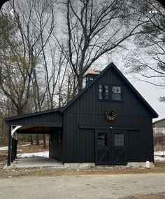 a large black barn with a covered porch