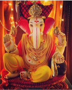 an elephant statue sitting on top of a red cloth covered chair with lights behind it