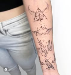 a woman's arm with tattoos on it, including birds and other things in the background