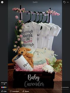 a baby gift basket with teddy bear, t - shirts and other items in it