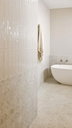 a white bath tub sitting next to a toilet in a bathroom