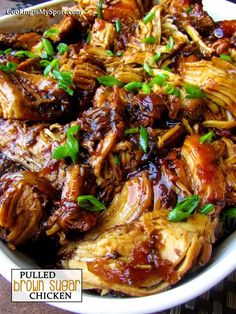 pulled pork and brown sugar chicken in a white bowl with green garnishes