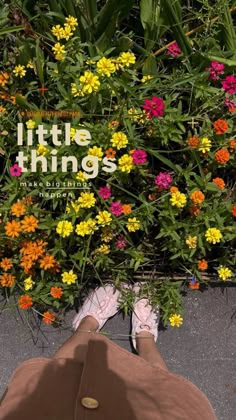 a person laying on the ground in front of flowers and plants with their feet up