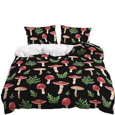 a bed covered in black and red mushrooms with green leaves on the bottom, along with white pillows