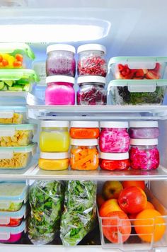 an open refrigerator filled with lots of different types of vegetables and fruit in plastic containers