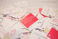 a pile of business cards sitting on top of each other with tags attached to them