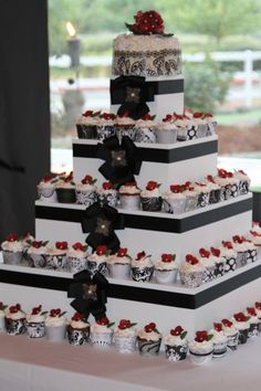 a three tiered cake with cupcakes on it